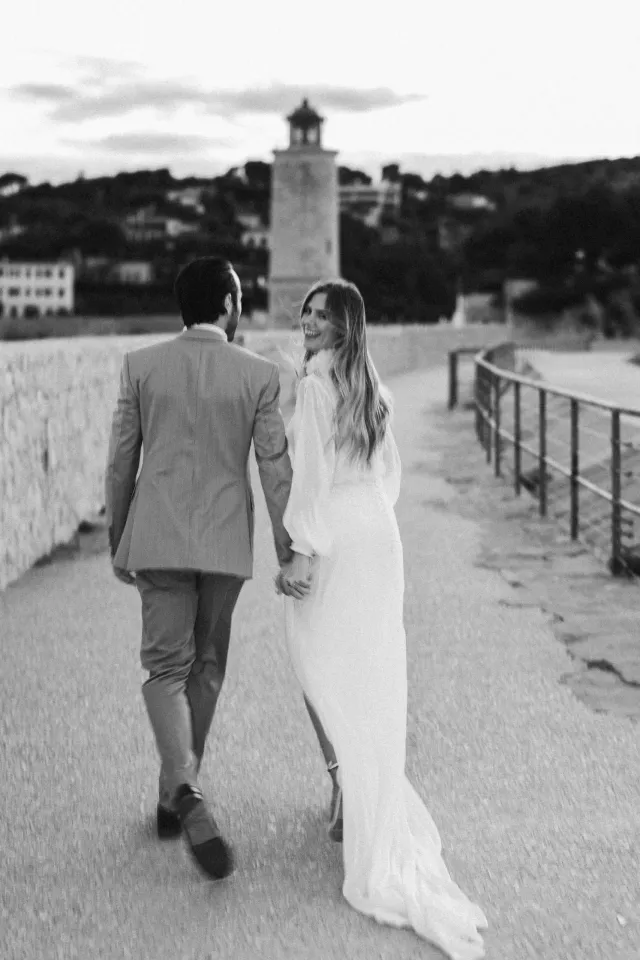 Les mariés marchent sur le ponton, photographie en noir et blanc