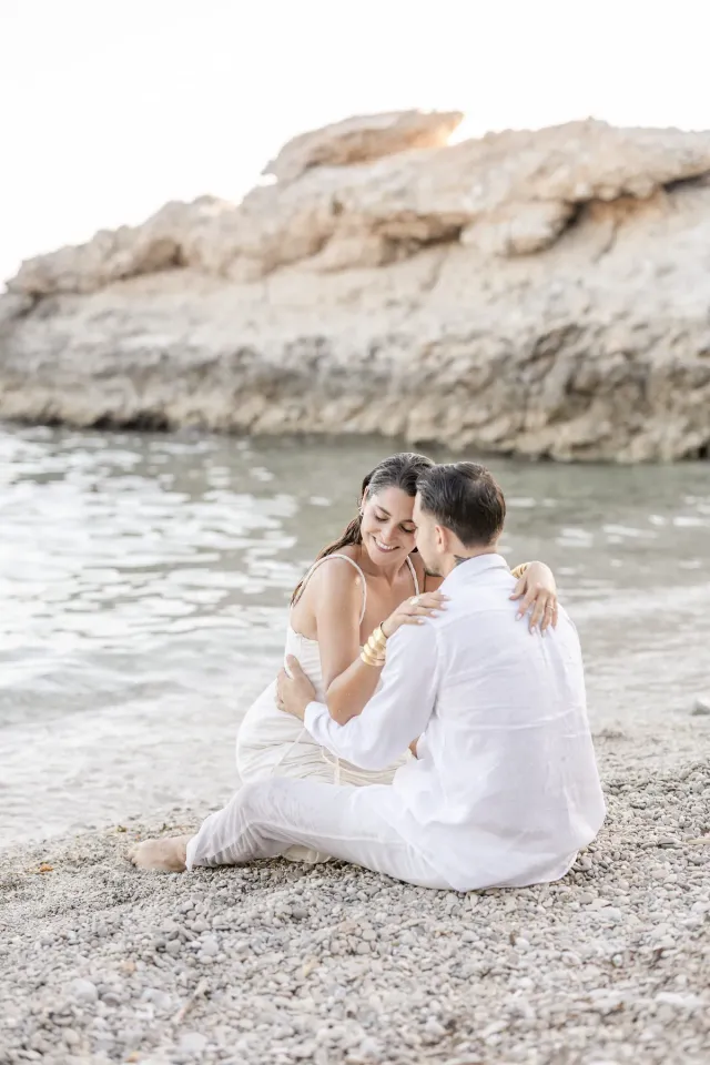 Portrait complice de Nancy et Lucas assis sur la plage de Sausset-les-Pins