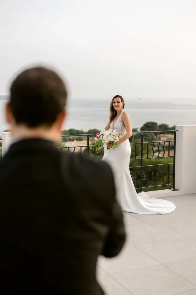 La mariée remonte l'allée vers le marié, mer en arrière-plan