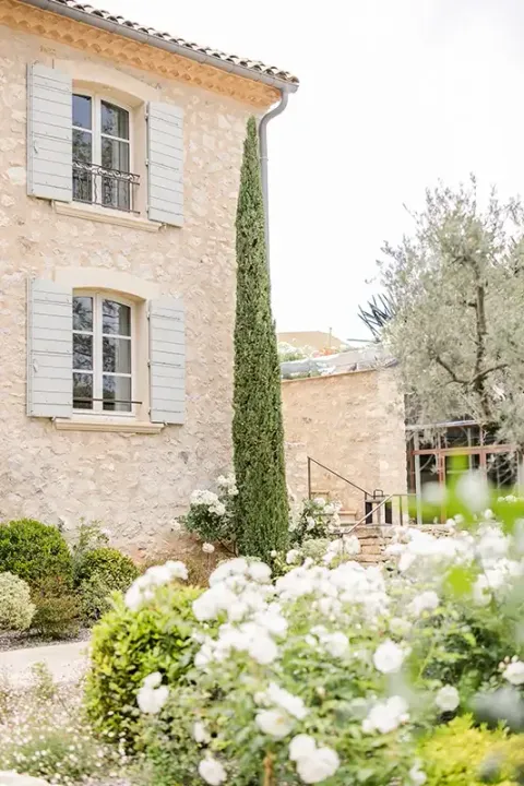 Façade en pierre dorée et cyprès sous le ciel d'été aixois