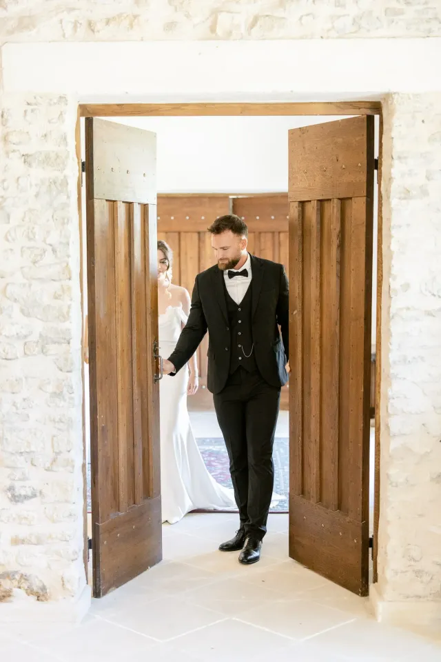 Le marié dans l'encadrement d'une porte en bois
