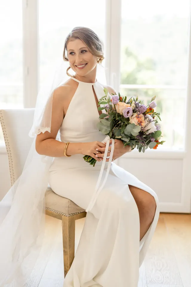 Mariée assise tenant son bouquet aux teintes pastel, domaine viticole du Var
