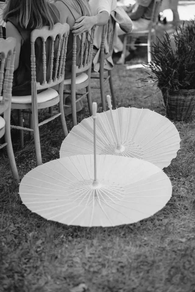 Parasols blancs repliés en bord de cérémonie, noir et blanc