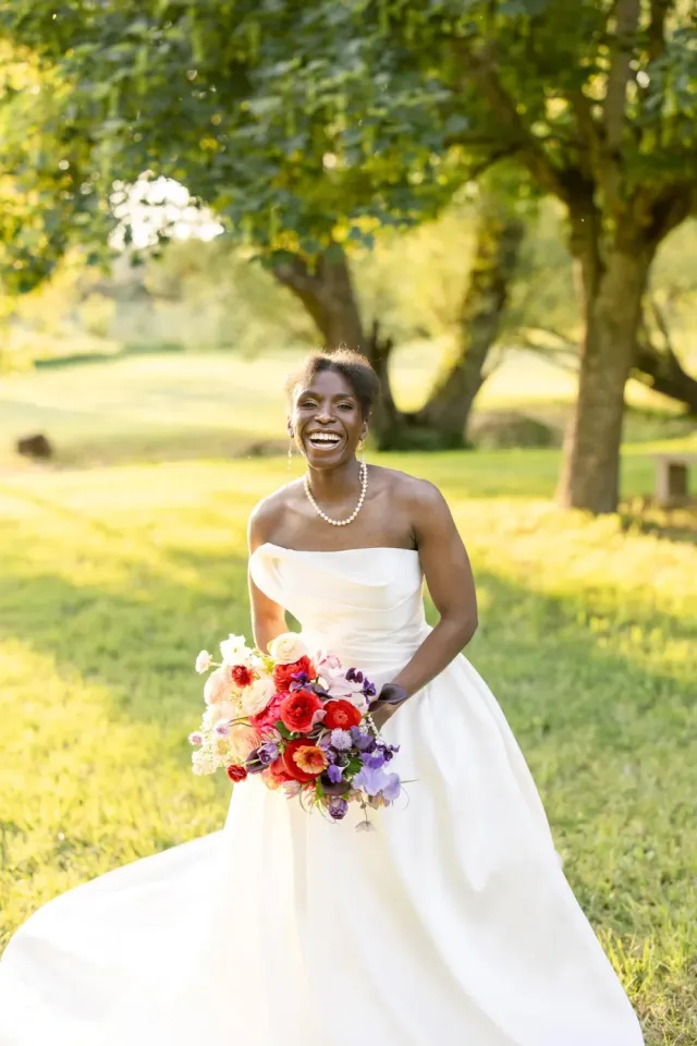 Portrait de la mariée et de son bouquet coloré dans le parc