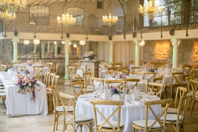 Tables rondes dressées sous la charpente pour la réception