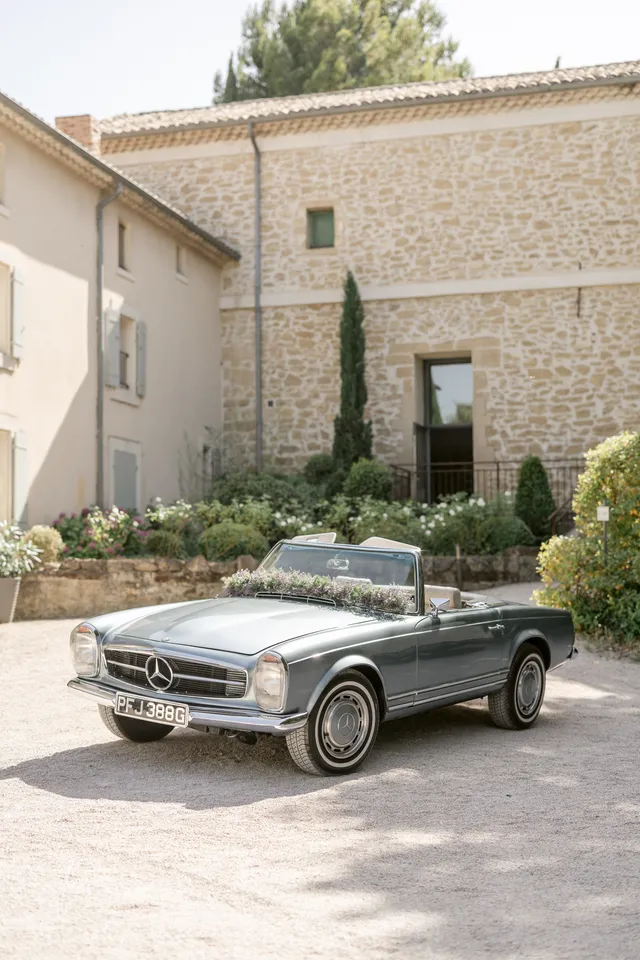 Cabriolet Mercedes ancien devant un mur en pierre
