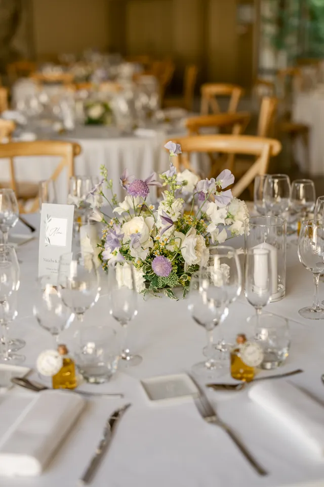 Centre de table floral et verrerie sur nappe blanche