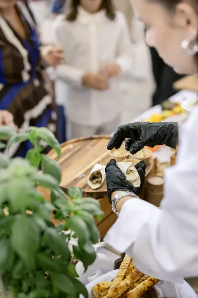 Chef servant des bouchées à la main au milieu des basilics, cuisine en direct lors d'un mariage intime