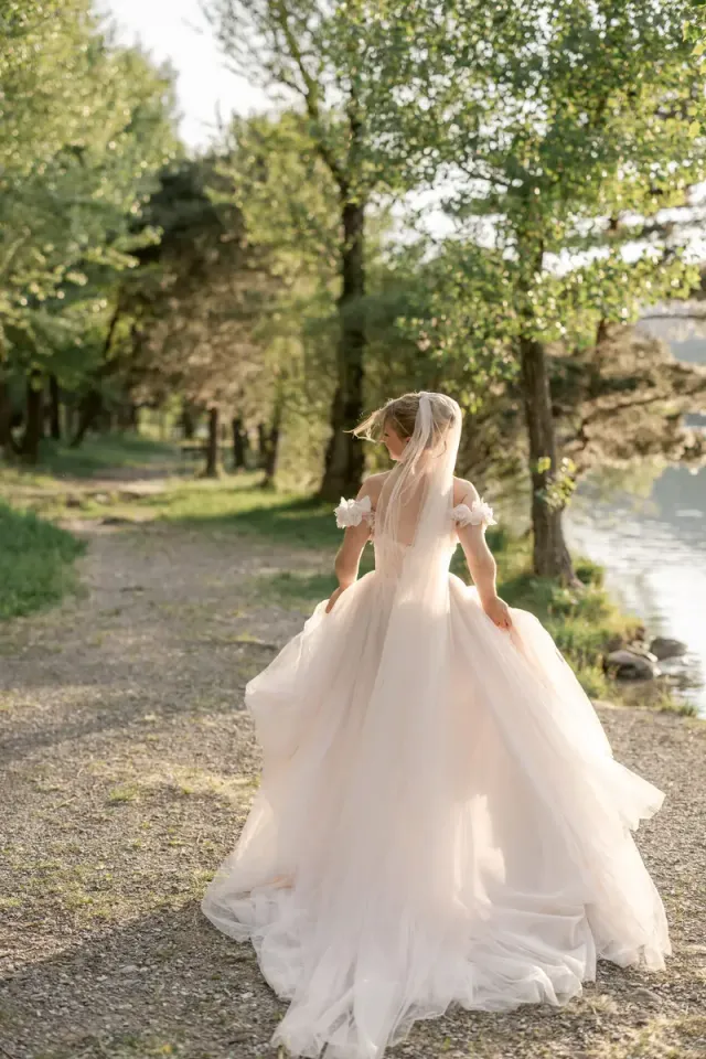 Mariée marchant seule sous les arbres, lumière douce de fin de journée en Provence