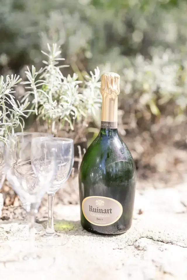 Champagne posé dans la lavande sèche, détail d'un mariage intime en Provence